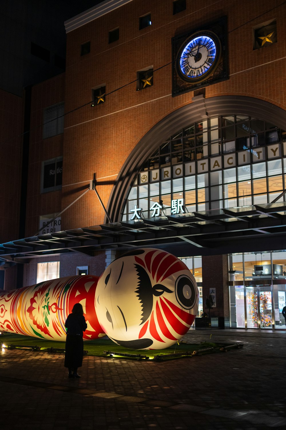 a giant red and white object in front of a building