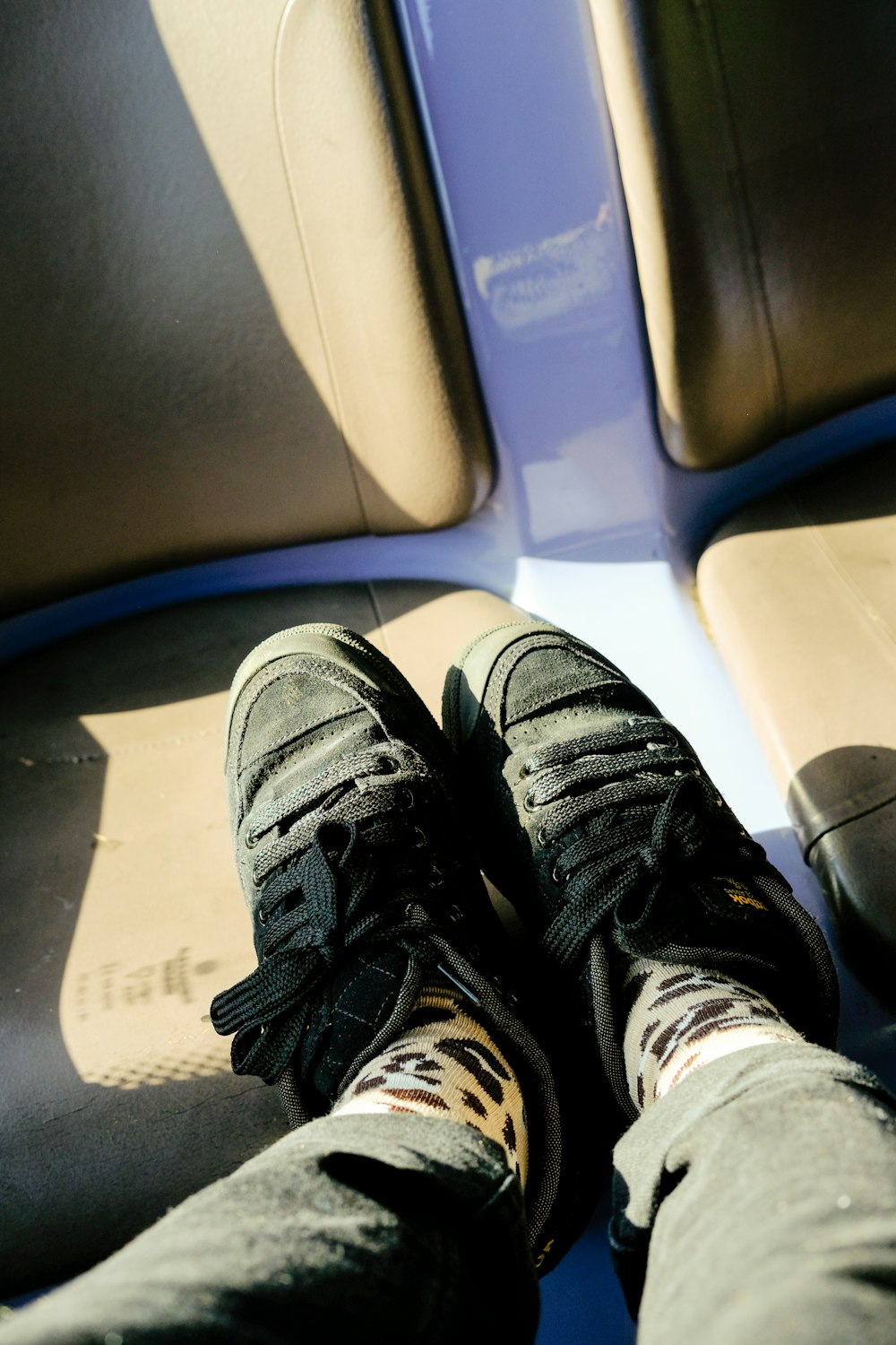 a person's feet resting on a seat on a train