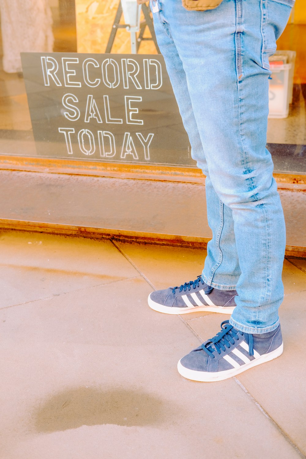 a person standing in front of a record sale sign