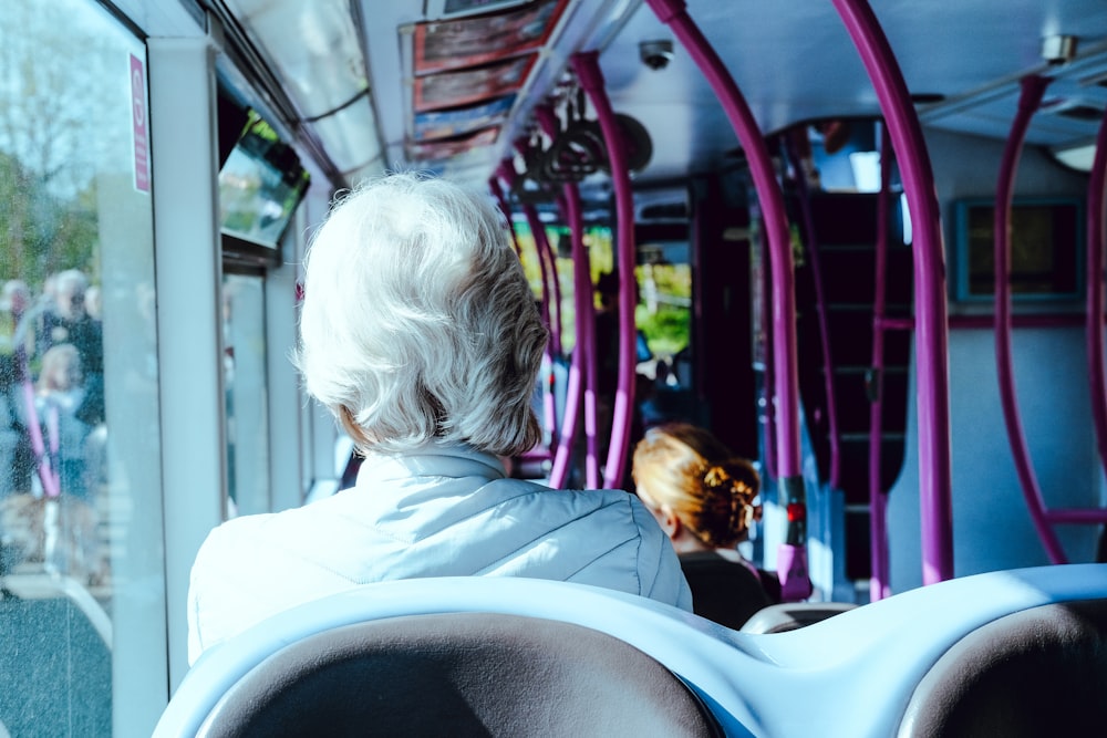 a woman sitting on a bus looking out the window