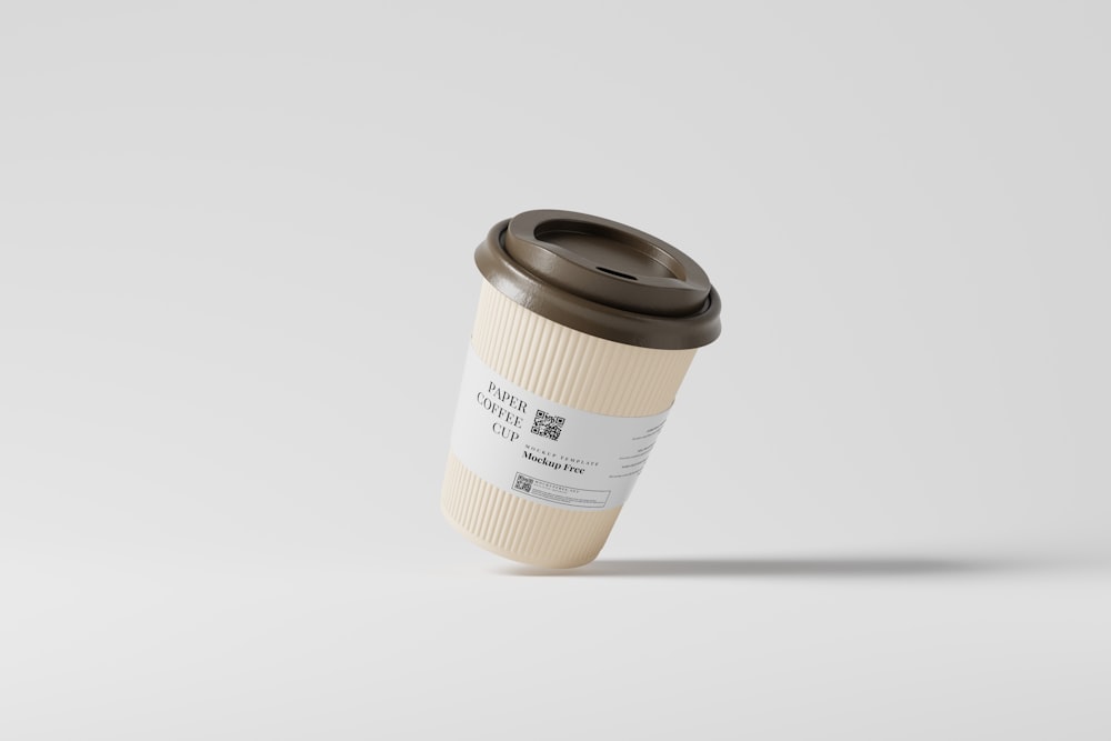 a coffee cup with a brown lid on a white background