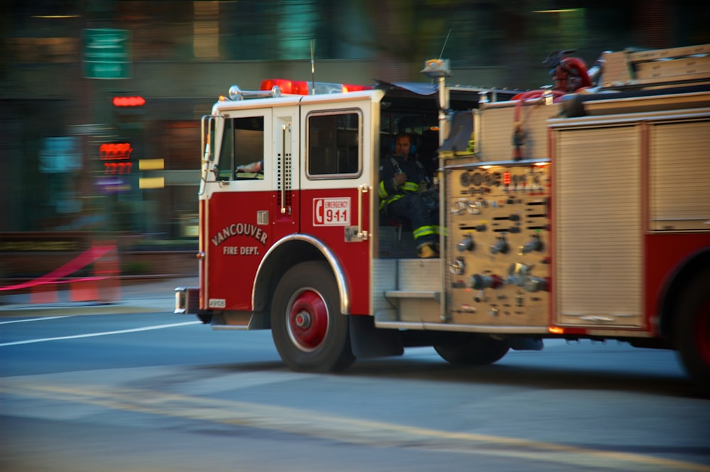 a red fire truck driving down a street