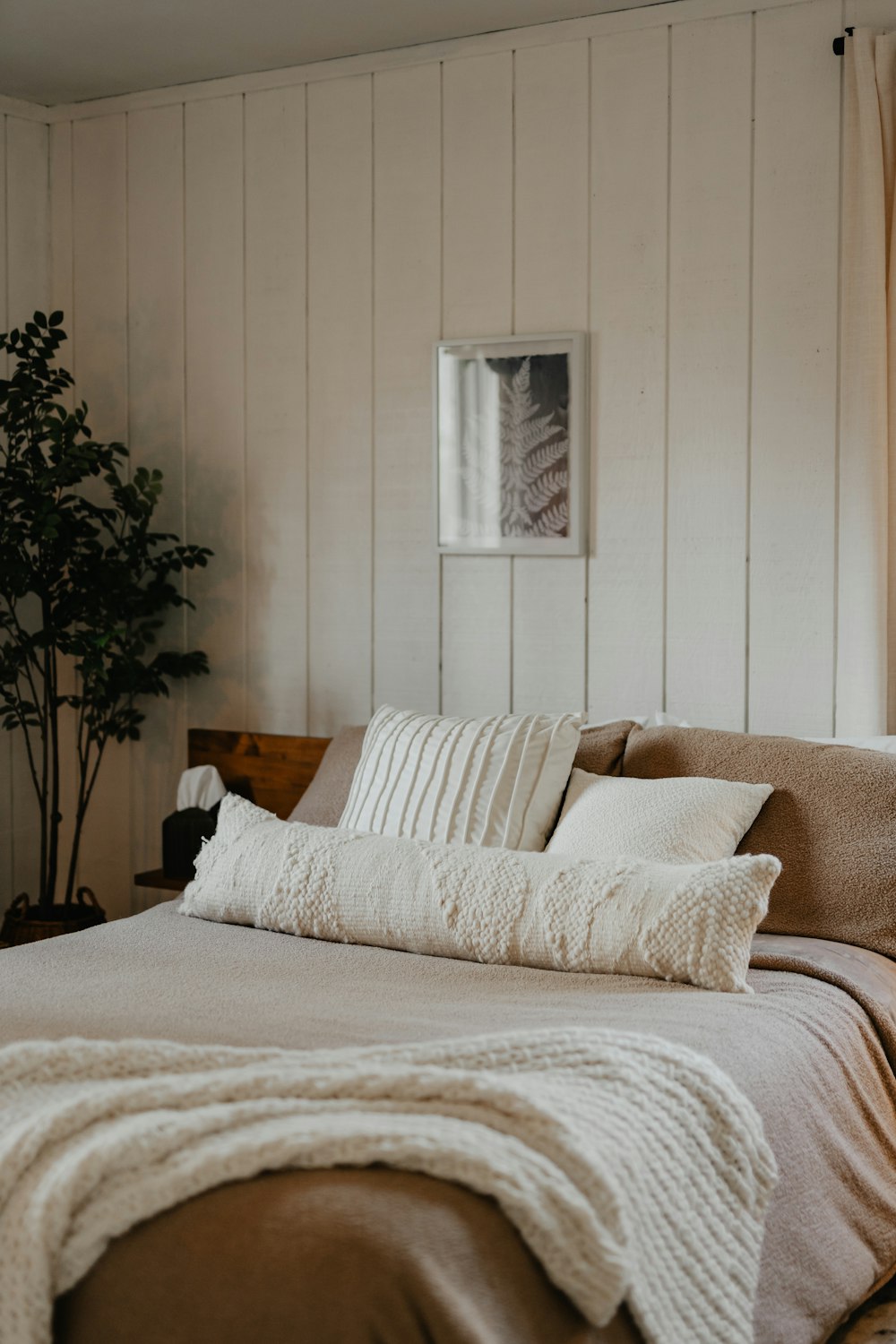 un letto con una coperta e cuscini in una stanza