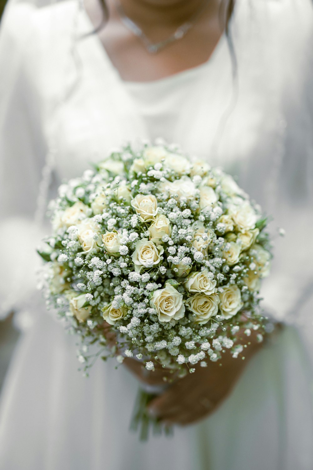 a close up of a person holding a bouquet of flowers