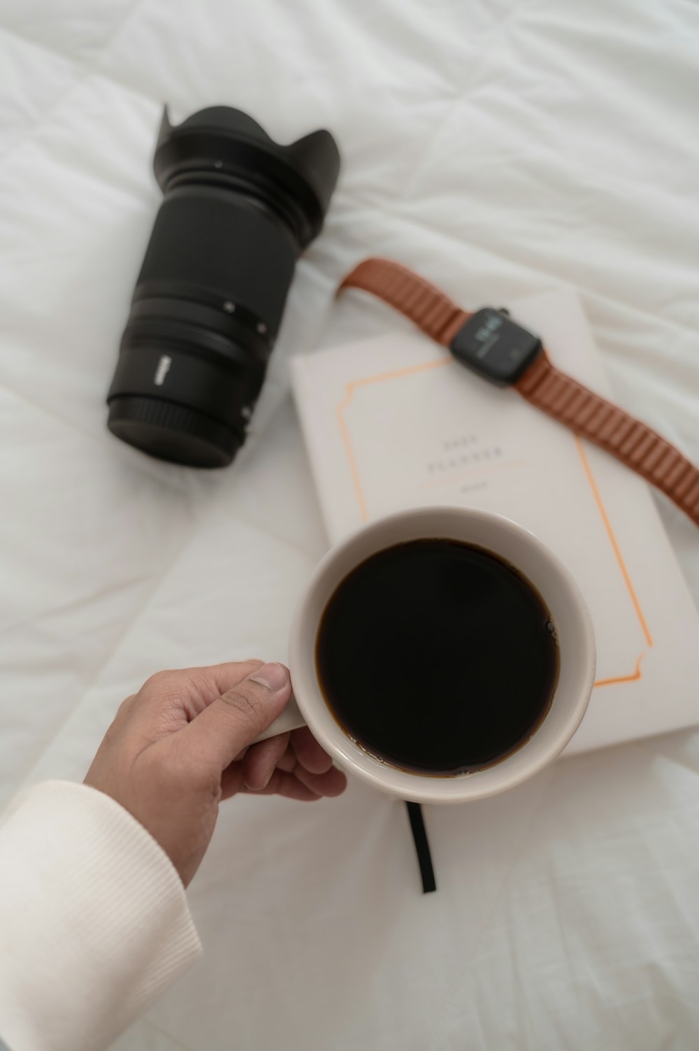a person holding a cup of coffee next to a camera