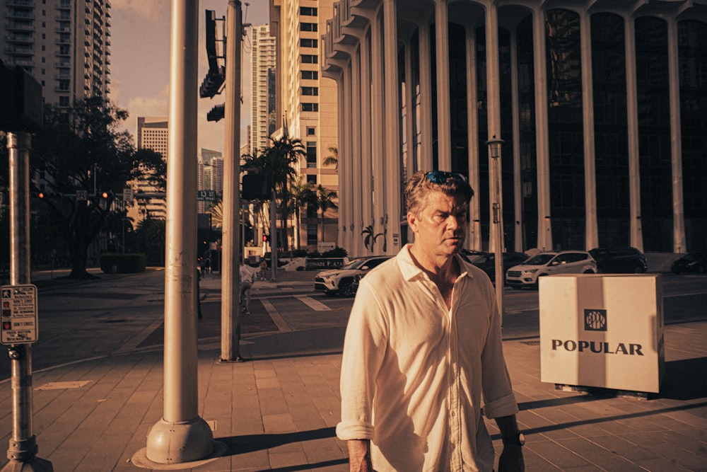 a man walking down a street next to tall buildings