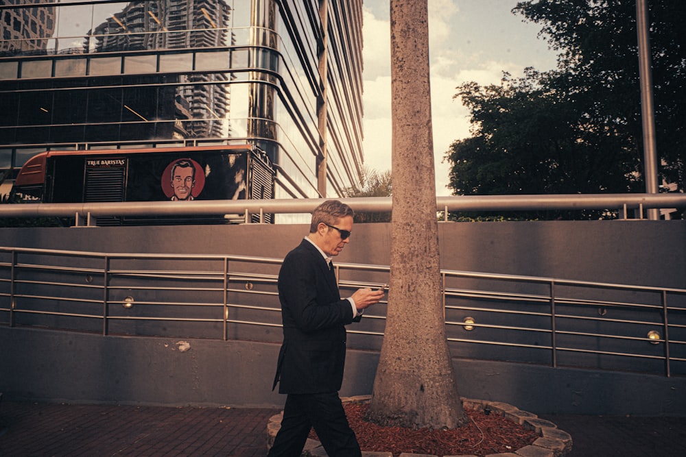 a man walking down a street while looking at his cell phone