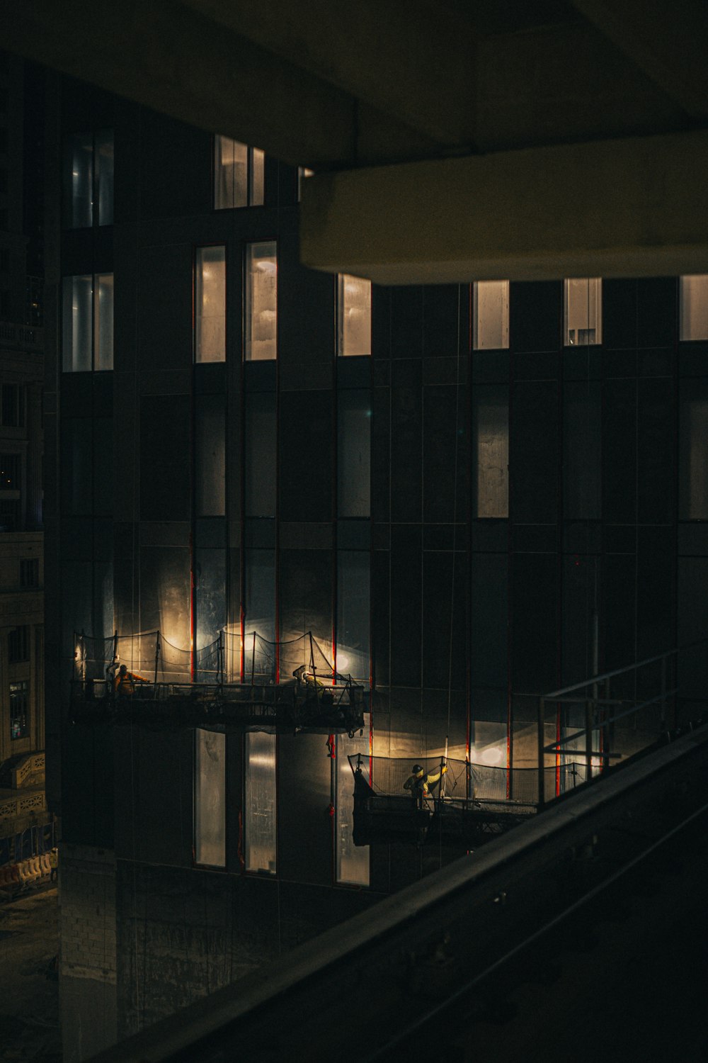 a train traveling past a tall building at night