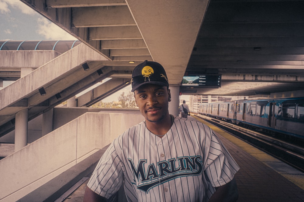 a baseball player standing in front of a train station