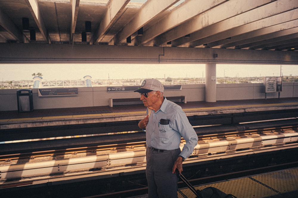 a man standing on a train platform with a suitcase