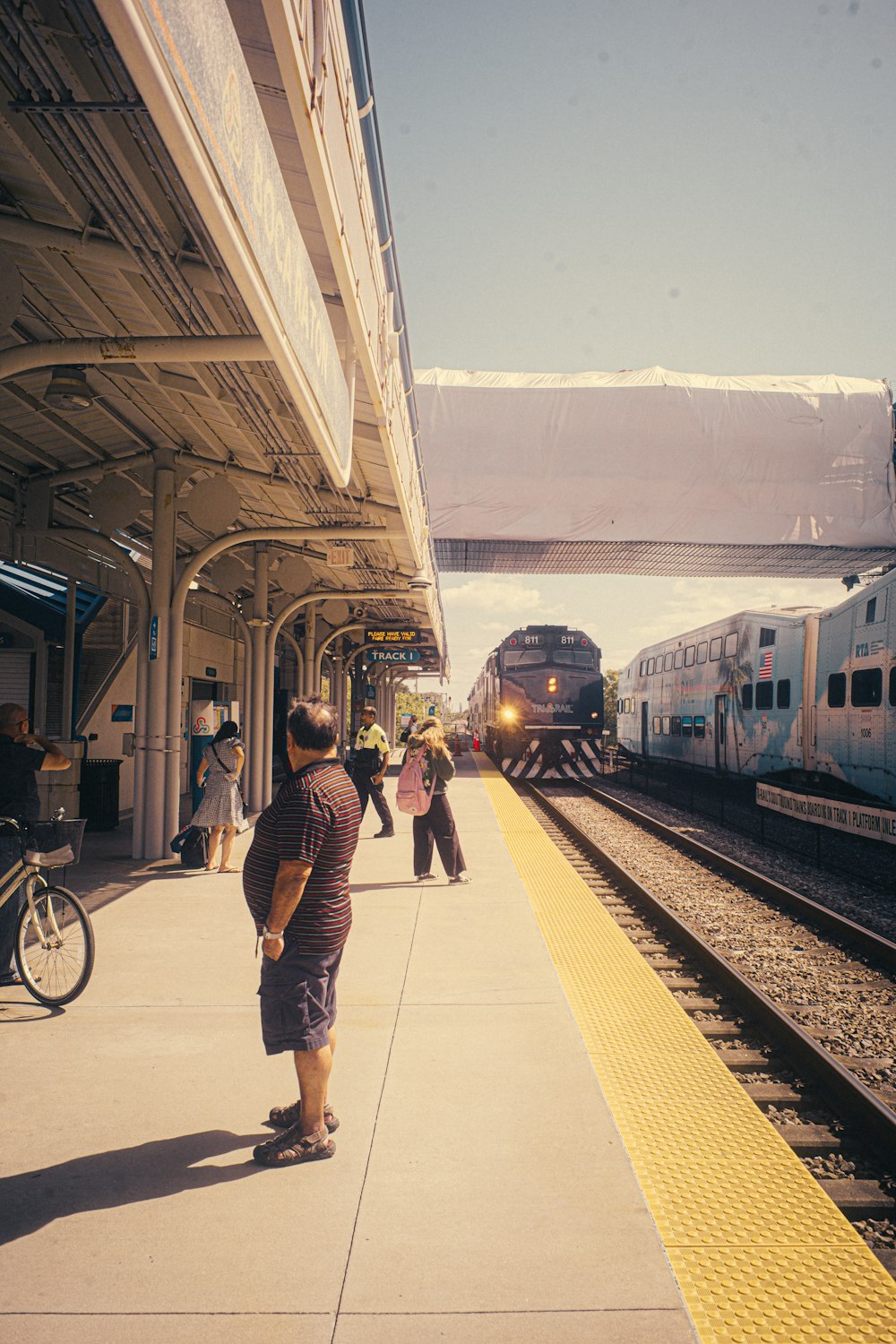 a group of people waiting for a train at a train station