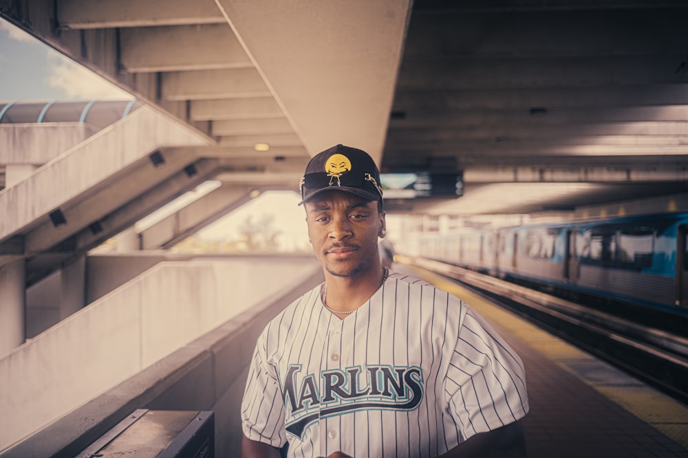 a man in a baseball uniform standing in a train station