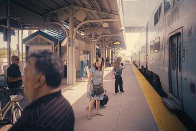 a group of people standing next to a train at a train station