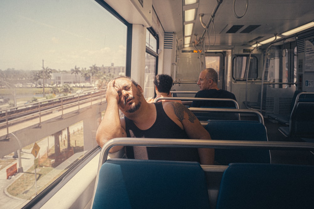 a man sitting on a train looking out the window