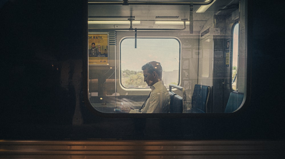 Ein Mann sitzt in einem Zug und schaut aus dem Fenster
