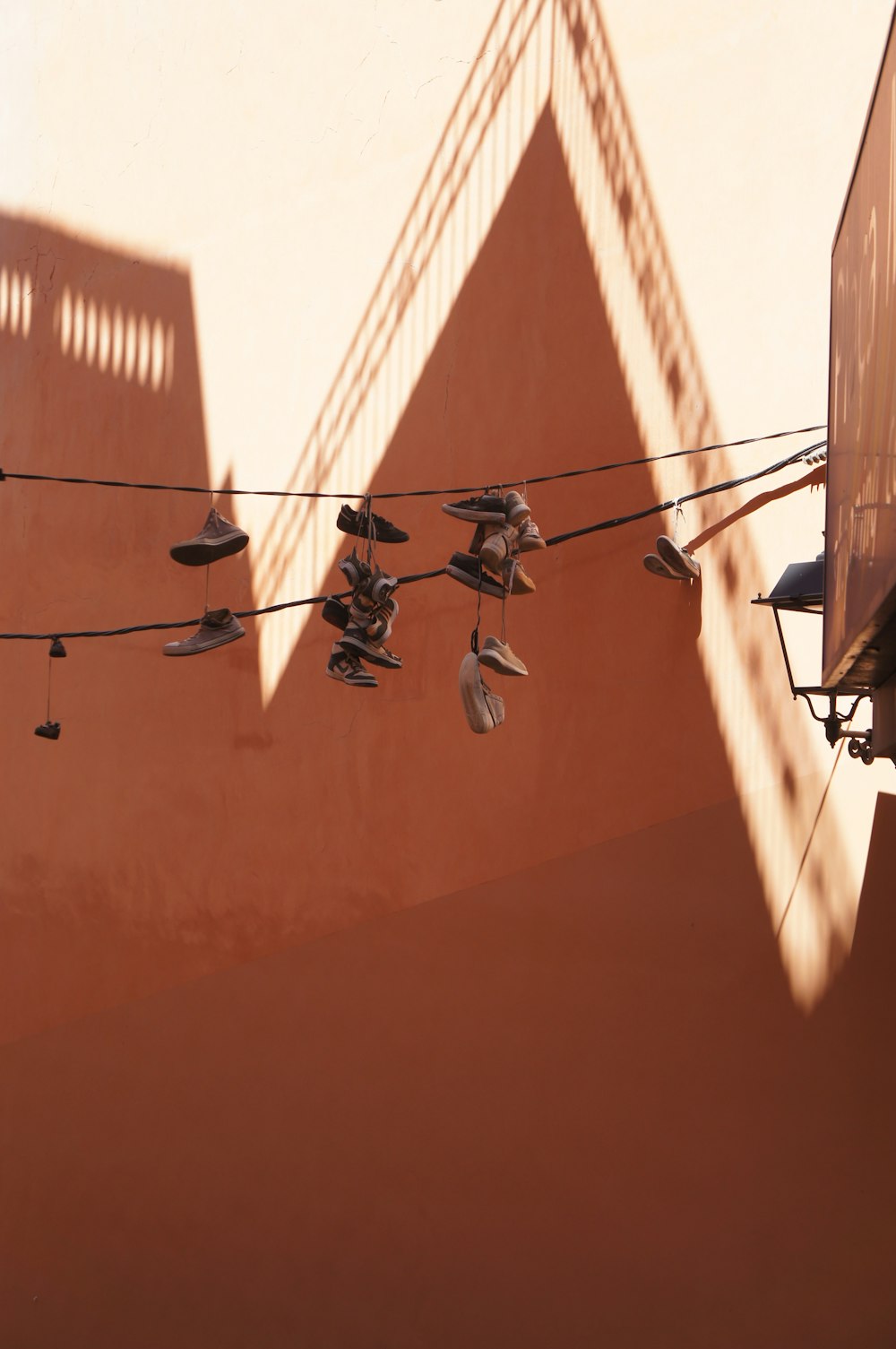 a line of shoes hanging from a line next to a building