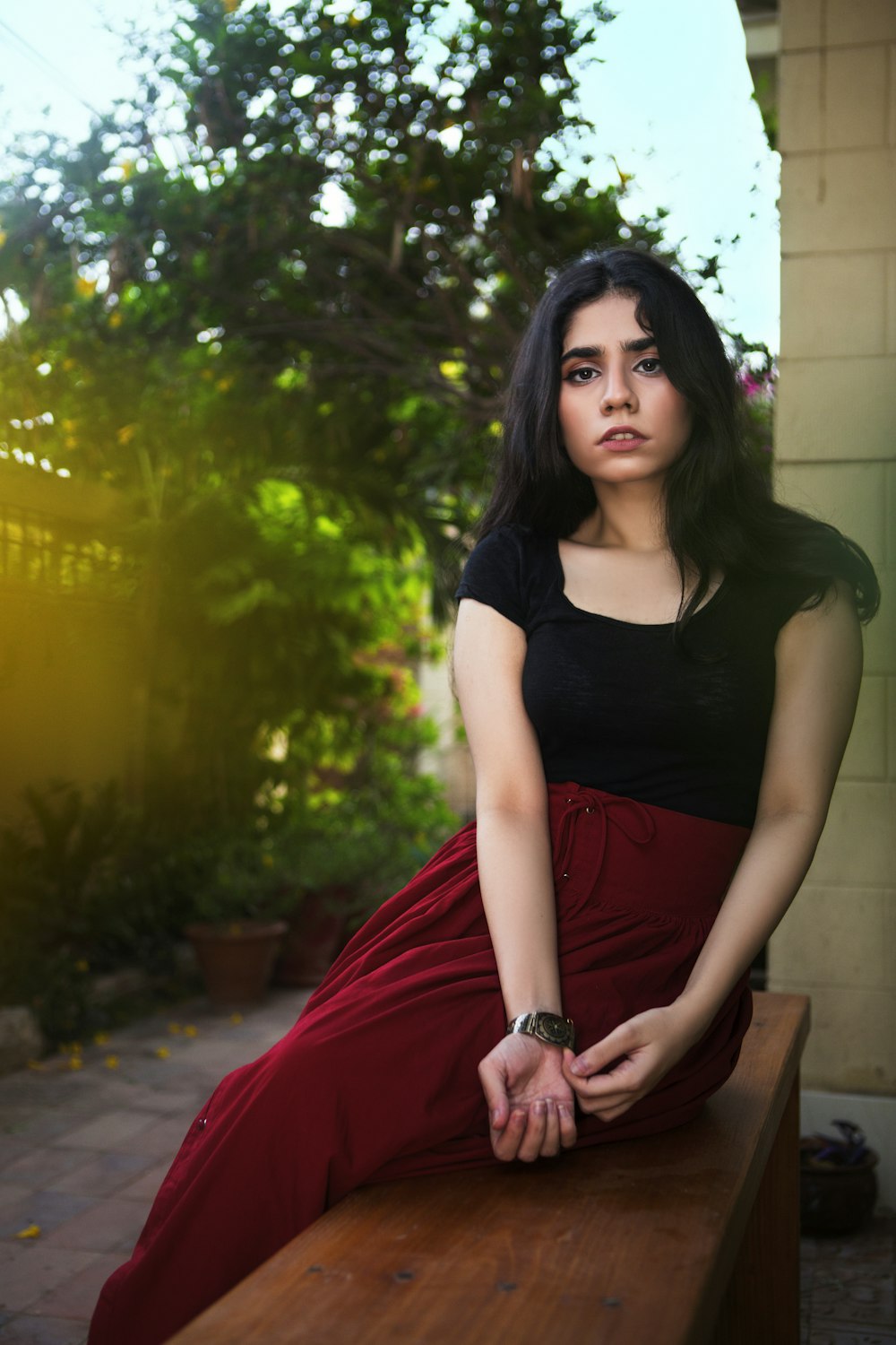 a woman is sitting on a bench outside