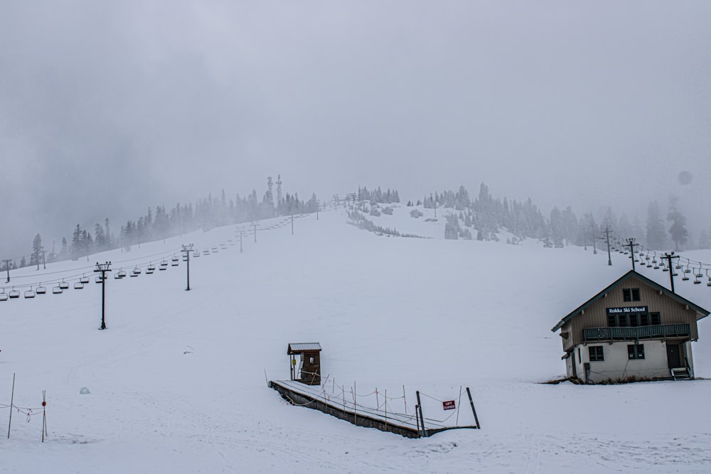 a snow covered ski slope with a house on it