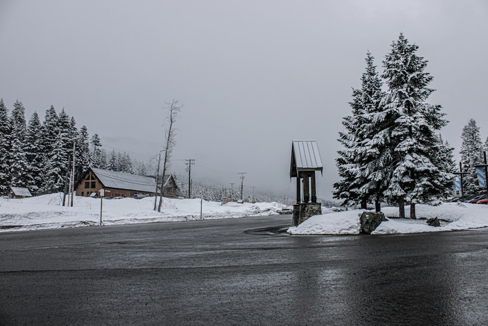 a snowy road with a clock tower in the middle of it