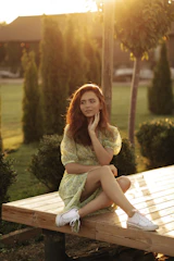 a woman sitting on top of a wooden bench