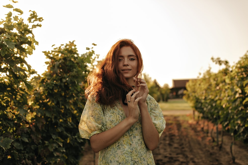 a woman standing in a field of vines