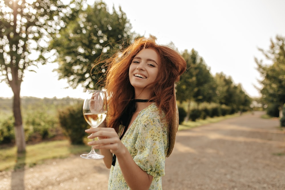 a woman is holding a glass of wine