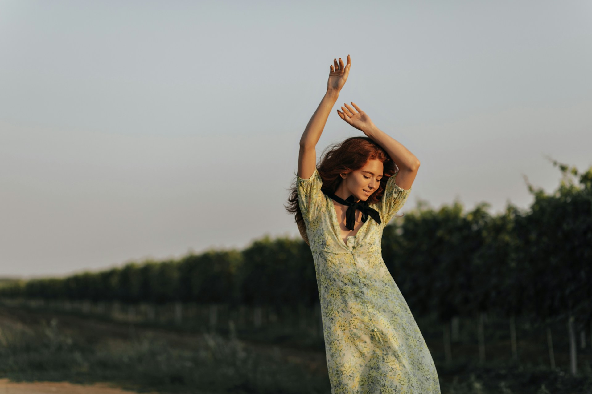 a woman in a yellow dress standing in a field