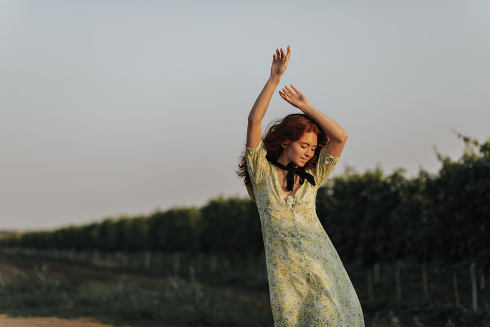 a woman in a yellow dress standing in a field