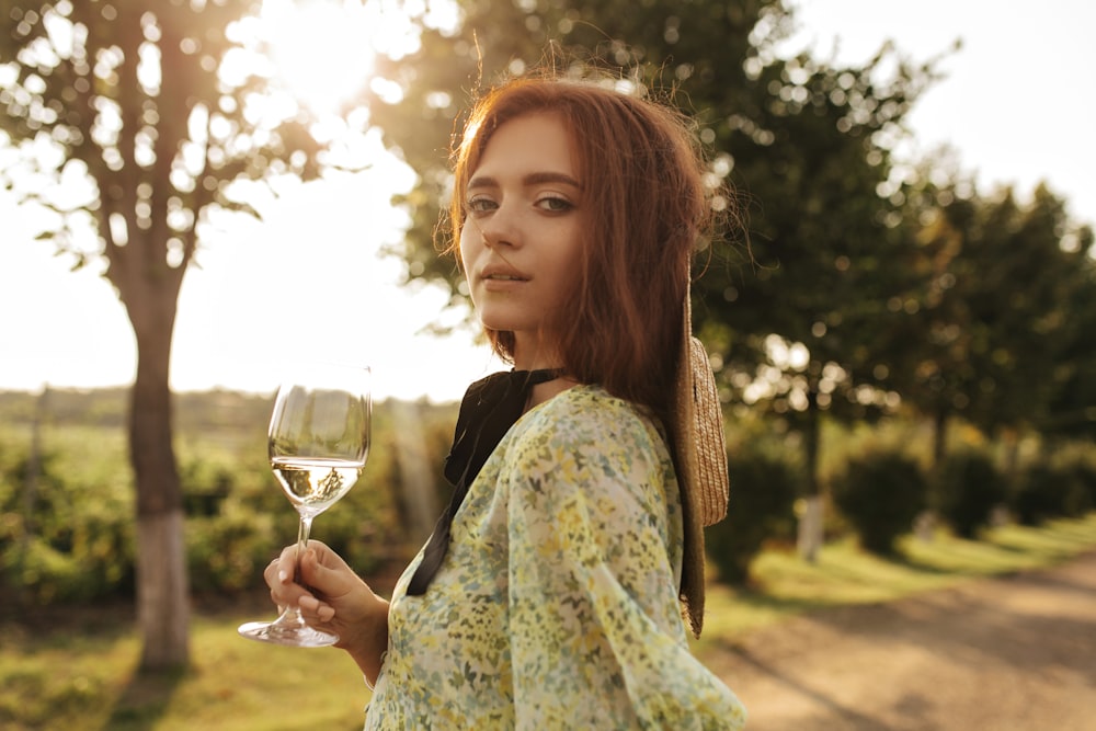 a woman is holding a glass of wine