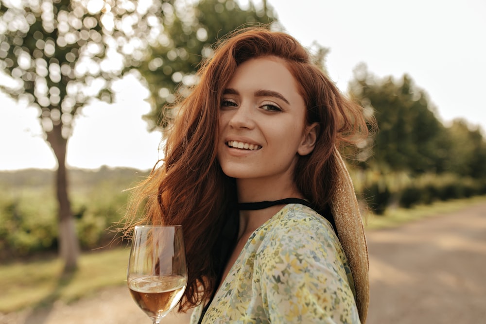 a woman with red hair holding a glass of wine
