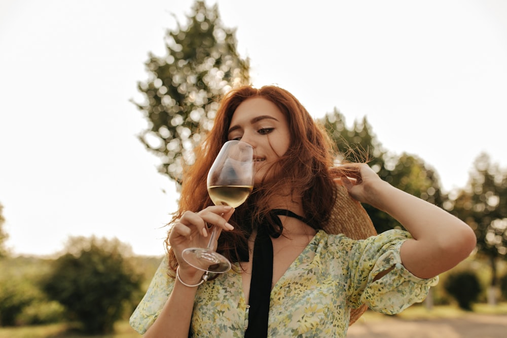 a woman is holding a glass of wine