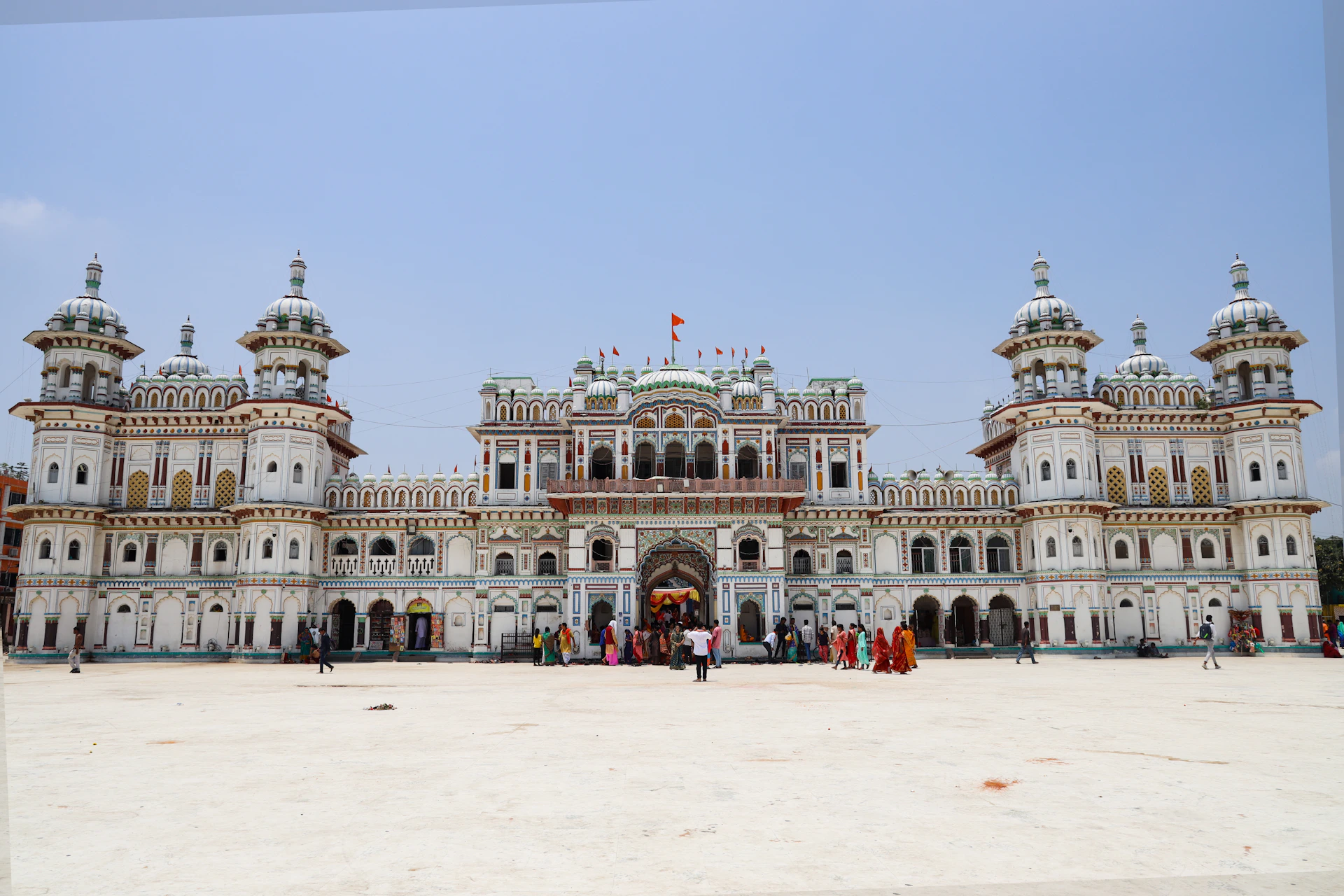 a large white building with lots of people standing in front of it