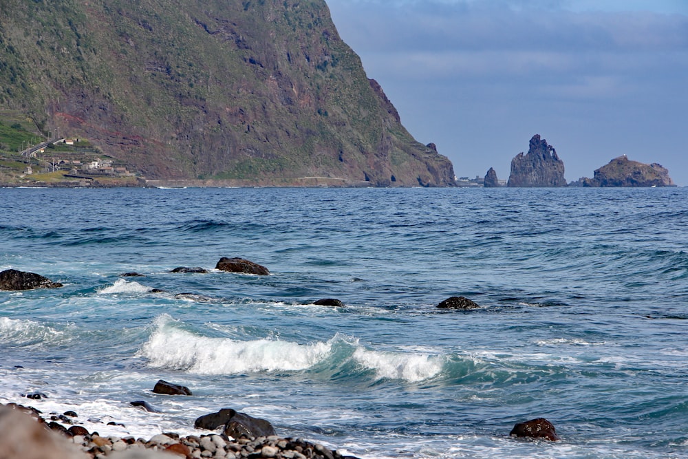 a large body of water with a mountain in the background