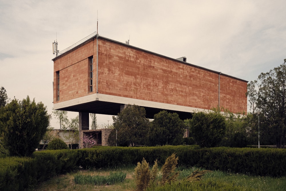 a tall building sitting on top of a lush green field