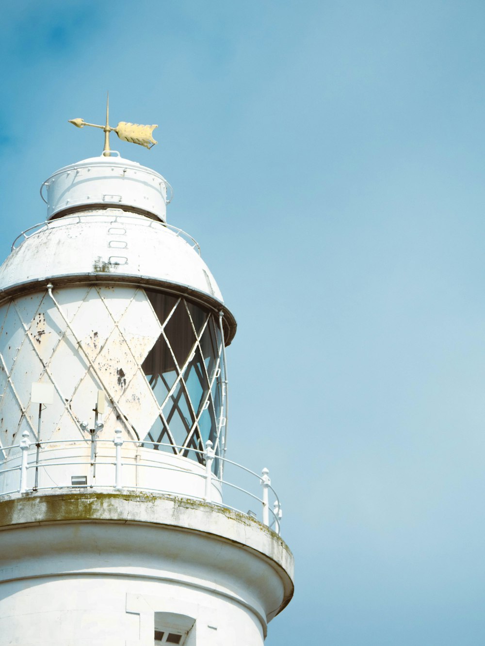 a white lighthouse with a flag on top of it