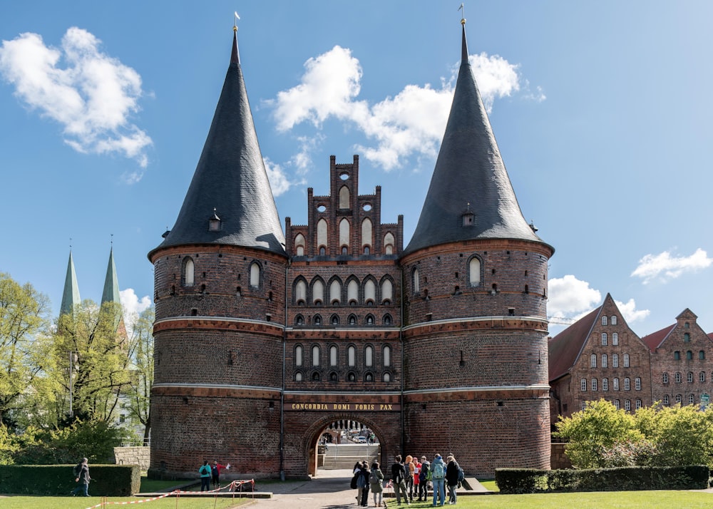 Un grupo de personas de pie frente a un castillo