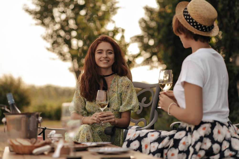 a woman sitting at a table with a glass of wine