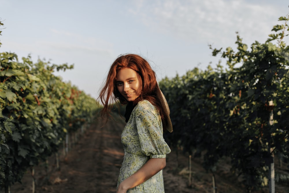 a woman standing in a field of grapes