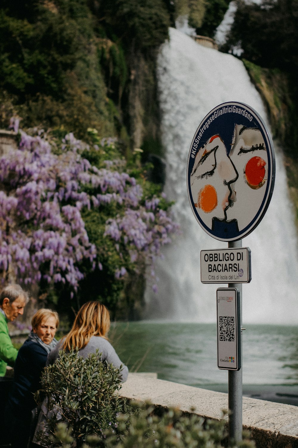 a group of people standing next to a waterfall