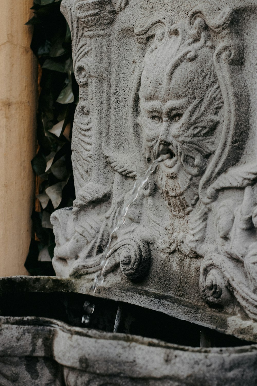 a close up of a fountain with a face on it