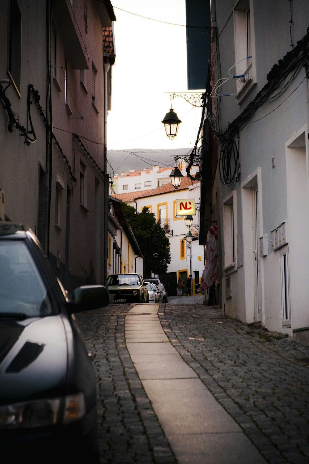 a car is parked on a cobblestone street