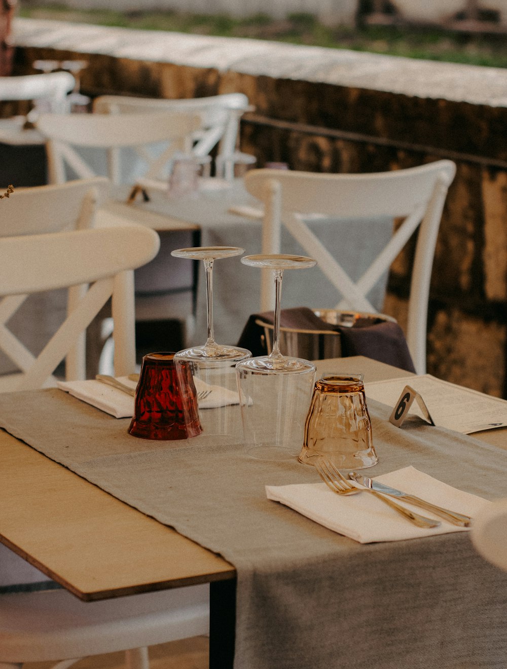 a table set up with wine glasses and napkins