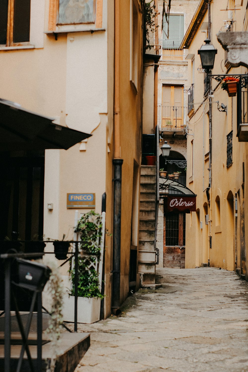 a narrow alley way with a clock on the wall