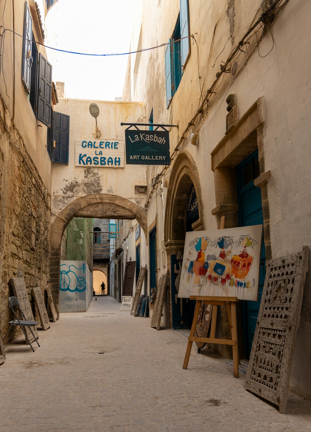 a narrow alleyway with a sign and easel
