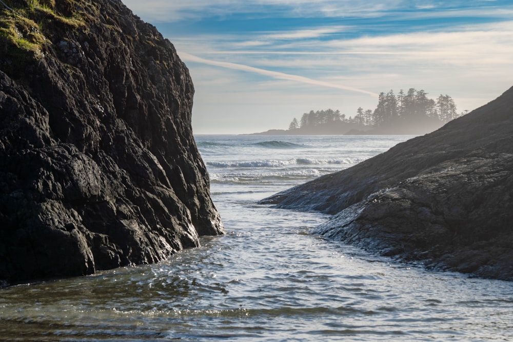 a river running between two large rocks near the ocean