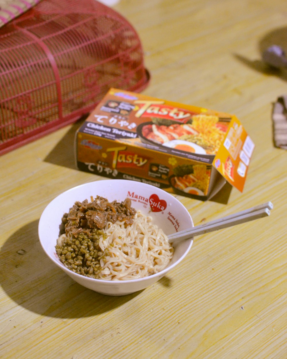 a bowl of noodles and a box of noodles on a table