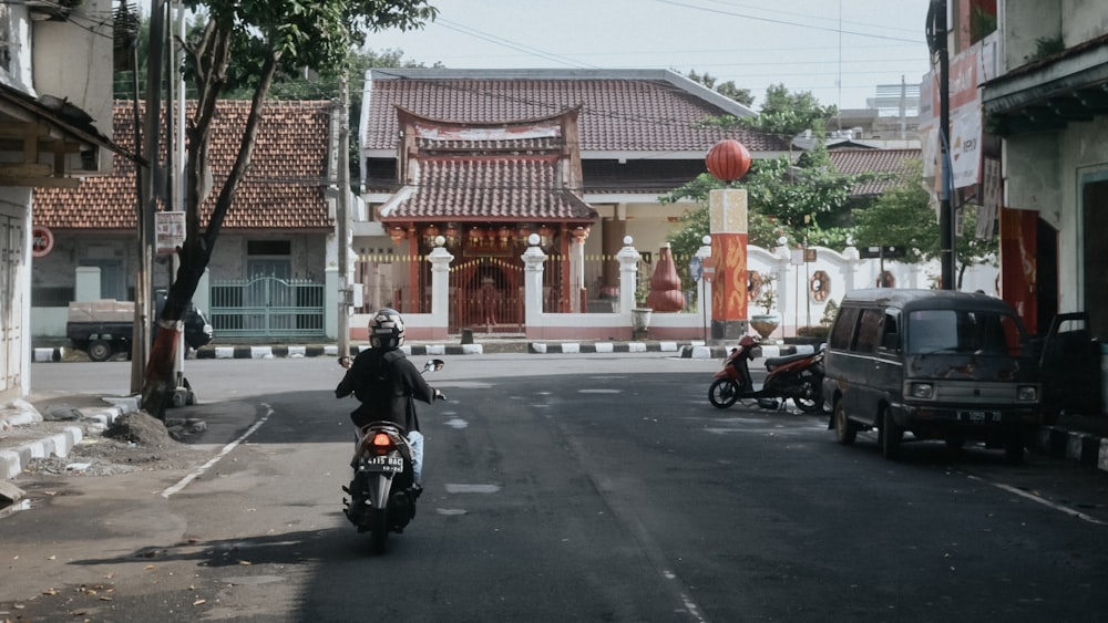 a man riding a motorcycle down a street