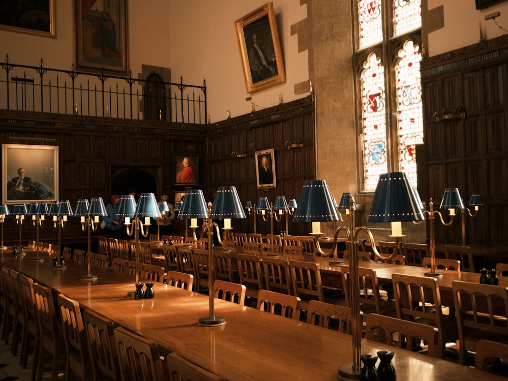 une longue table avec de nombreuses chaises et lampes dessus