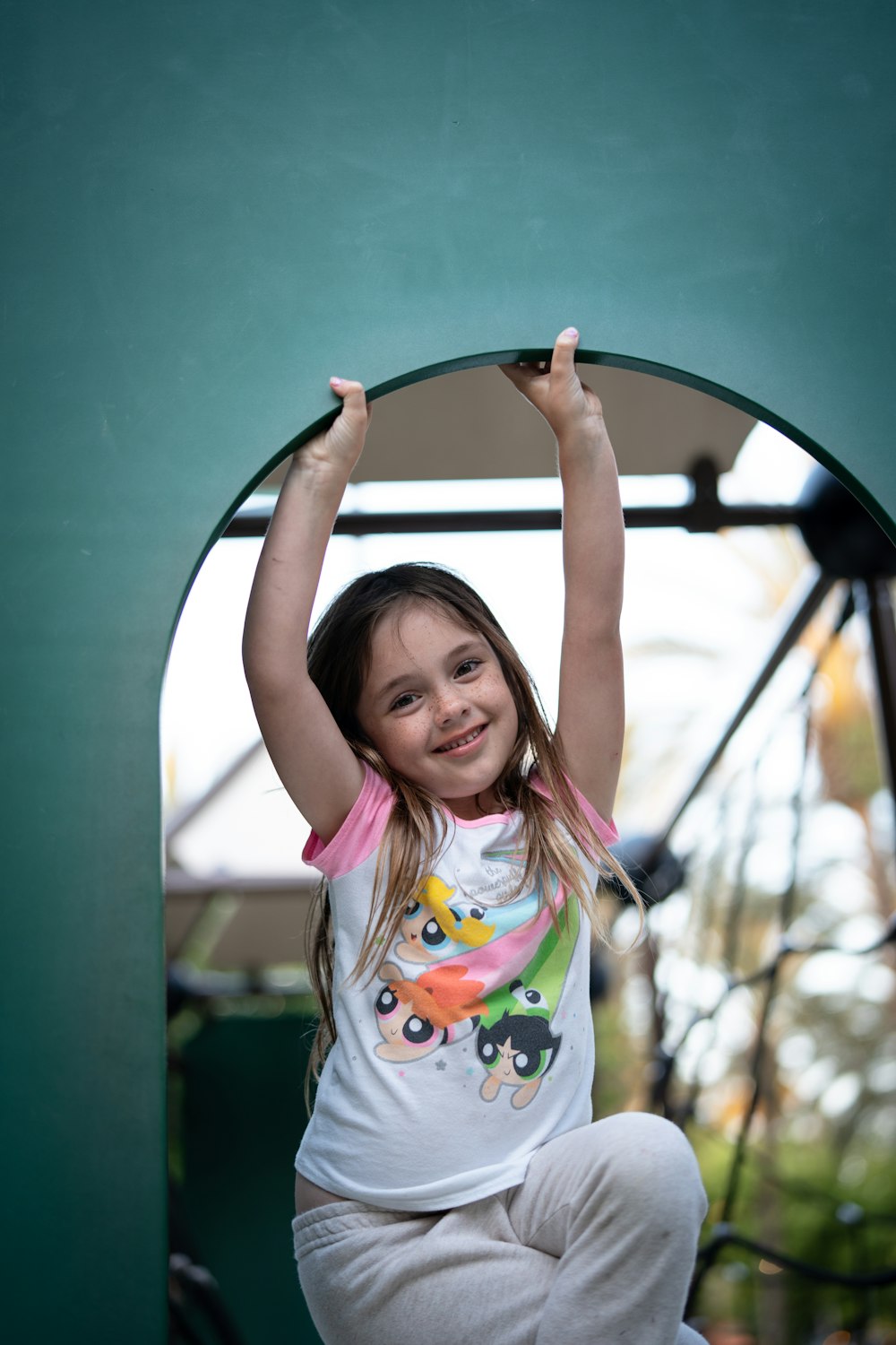 a little girl that is standing on a slide