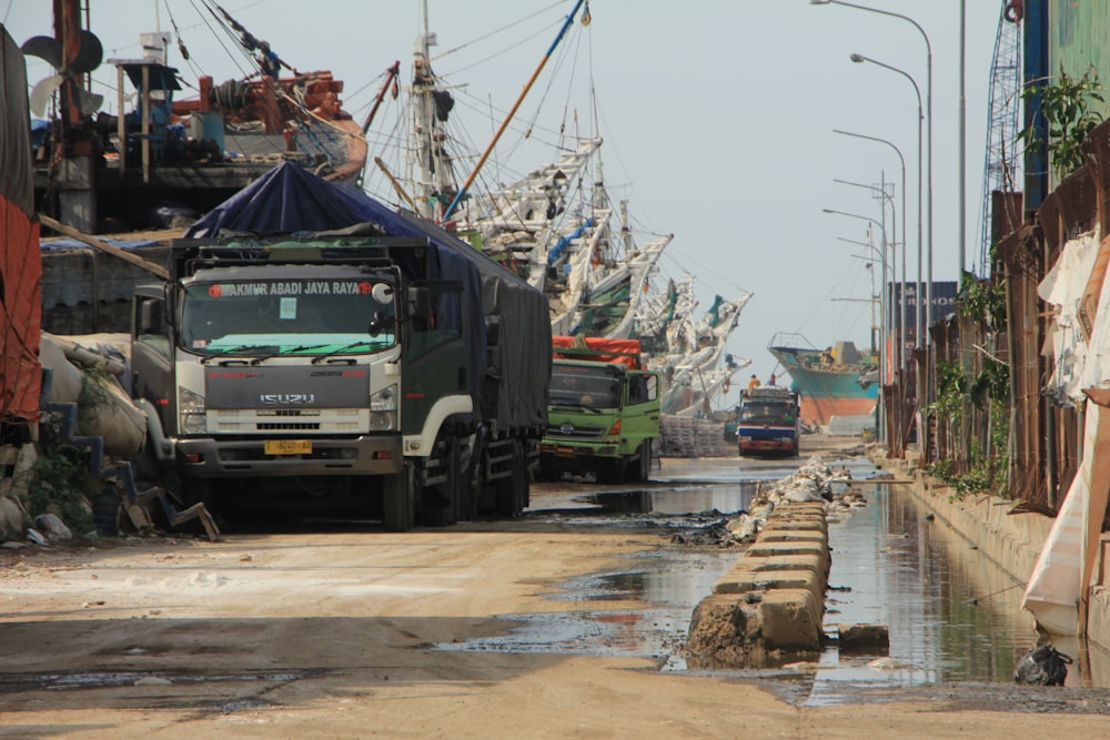 a truck driving down a street next to a bunch of boats